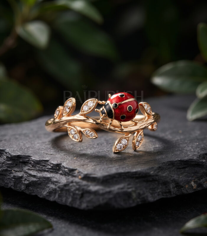 Nature-inspired ladybug and leafy vine moissanite ring featuring a red enamel ladybug and pavé accent stones set in 14K yellow gold plated silver.