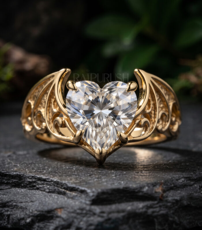 14K gold-plated sterling silver ring featuring a 1CT heart-cut moissanite center stone flanked by intricate bat or dragon wing filigree shoulders.